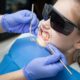 girl getting teeth checked by dentist and she's wearing sunglasses