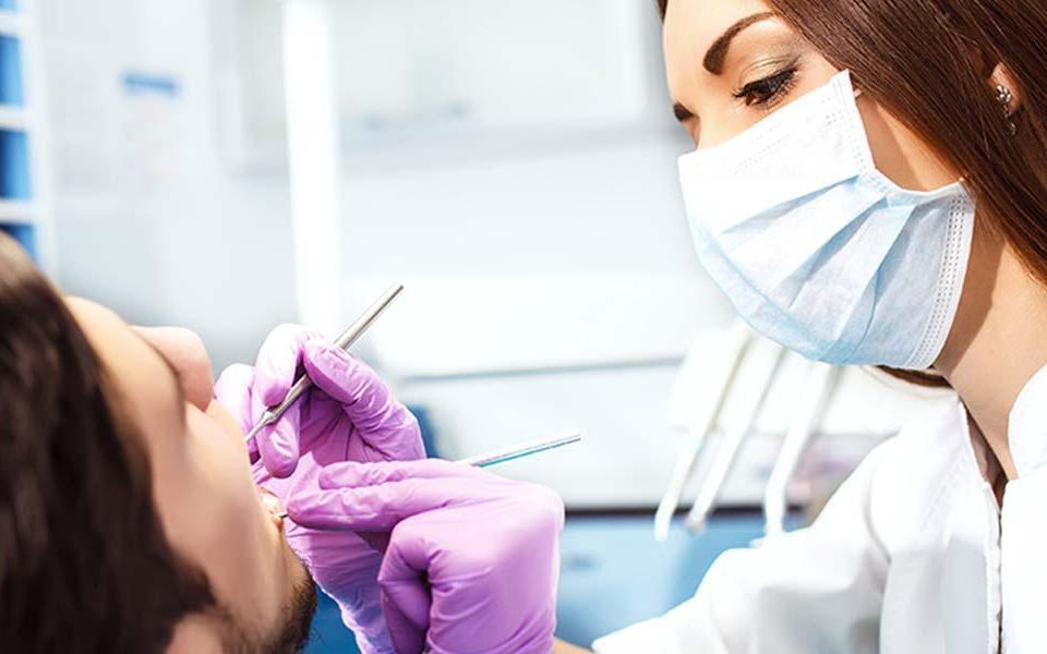 female doctor checking patient during dental exam
