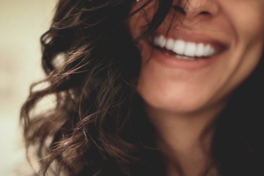 woman with curly hair and white teeth smiling