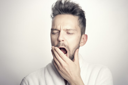 man yawning and holding his jaw