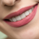 woman smiling with pink lipstick and teeth showing