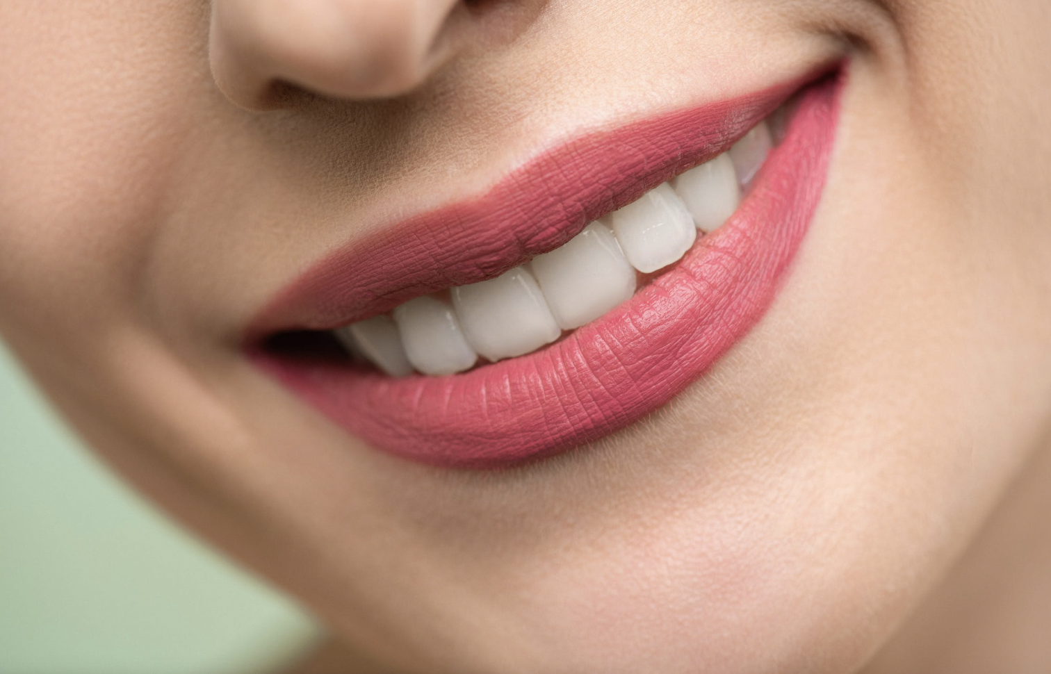 woman smiling with pink lipstick and teeth showing