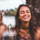 two women smiling with their teeth outside